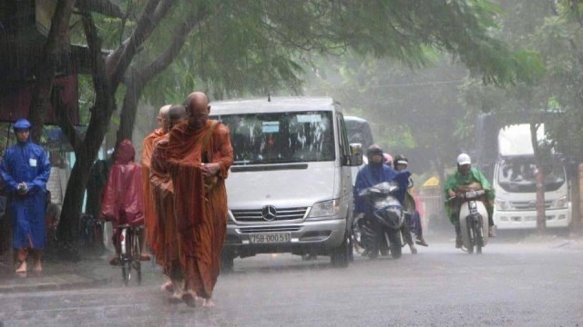 “ชาวพุทธเวียดนาม รอใส่บาตรพระเณรในเช้าที่ฝนตกหนัก ภาพแห่งความประทับใจ