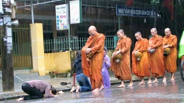 “ชาวพุทธเวียดนาม รอใส่บาตรพระเณรในเช้าที่ฝนตกหนัก ภาพแห่งความประทับใจ