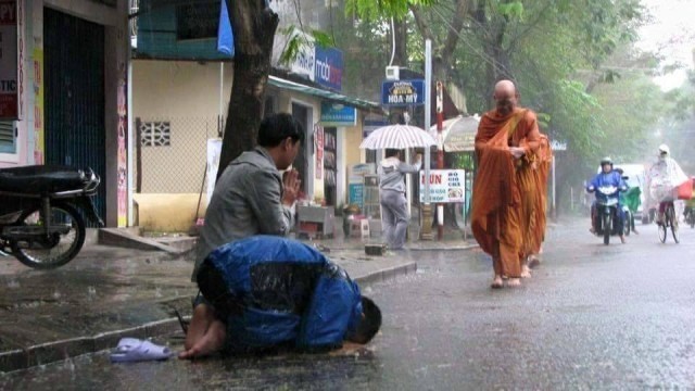 “ชาวพุทธเวียดนาม รอใส่บาตรพระเณรในเช้าที่ฝนตกหนัก ภาพแห่งความประทับใจ