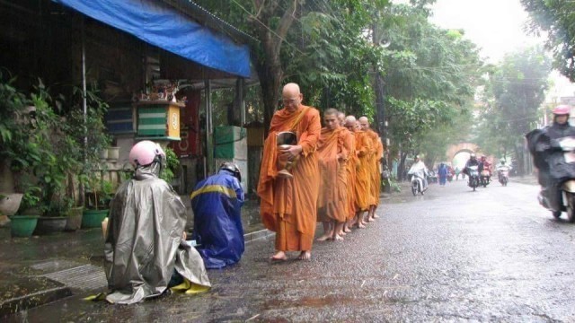 “ชาวพุทธเวียดนาม รอใส่บาตรพระเณรในเช้าที่ฝนตกหนัก ภาพแห่งความประทับใจ